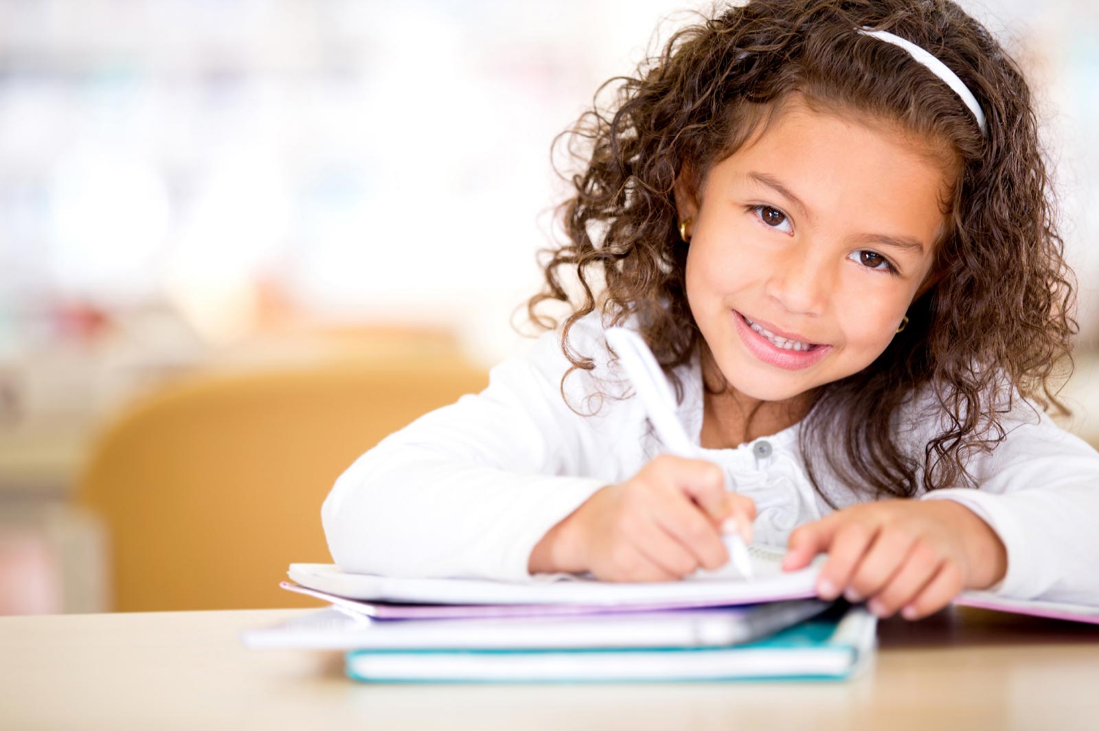 Little girl writing in a notebook.